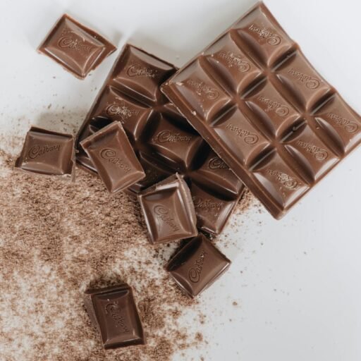 Tantalizing image of assorted chocolate bars and cocoa powder on a clean white background.